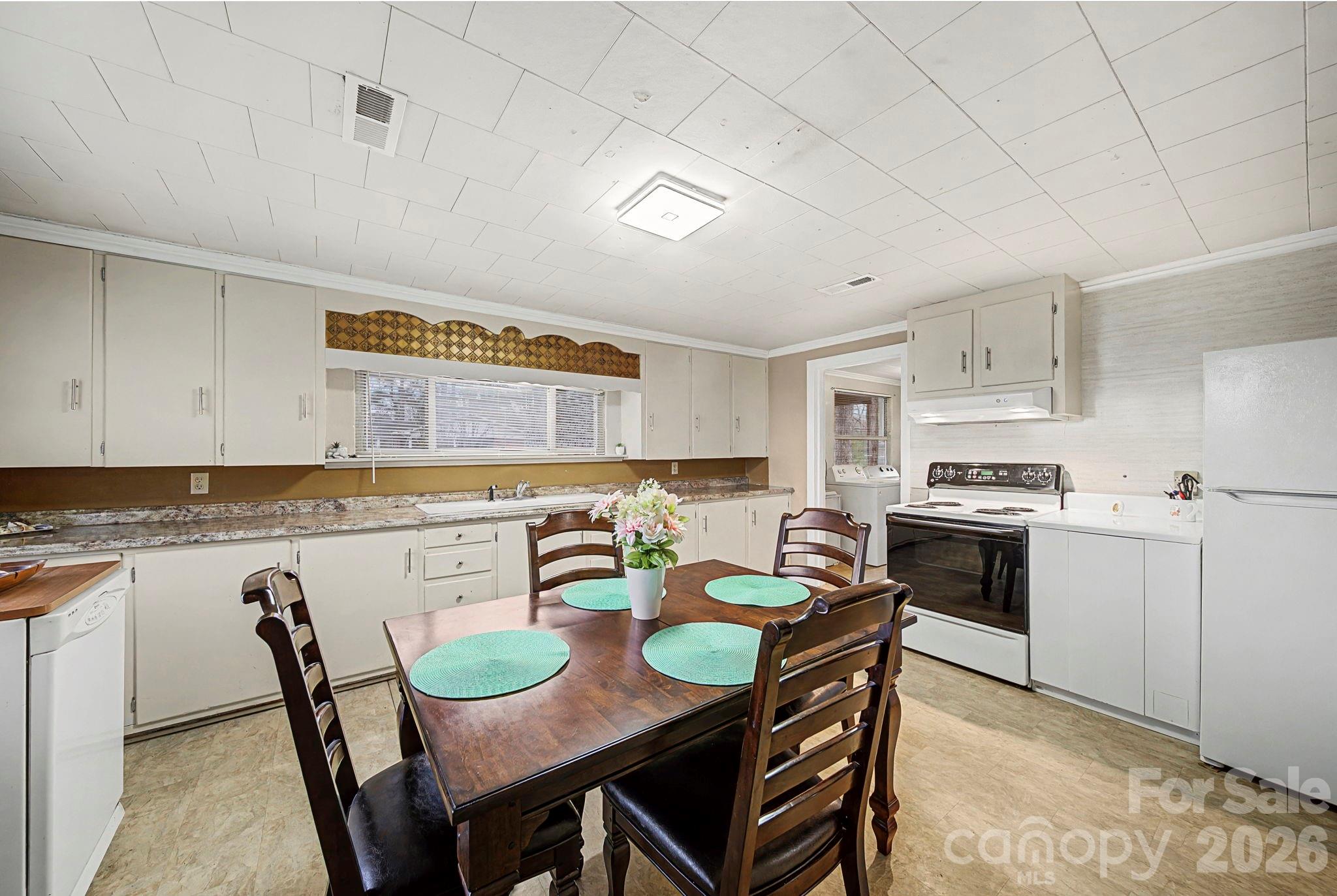 14309 Liberty Hill Church Road Oakboro, NC 28129 - Photo 11 of 37 a kitchen with granite countertop white cabinets and stainless steel appliances