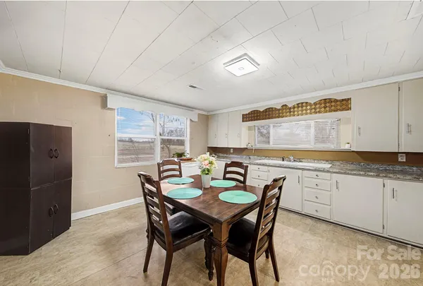 a kitchen with a dining table chairs and refrigerator