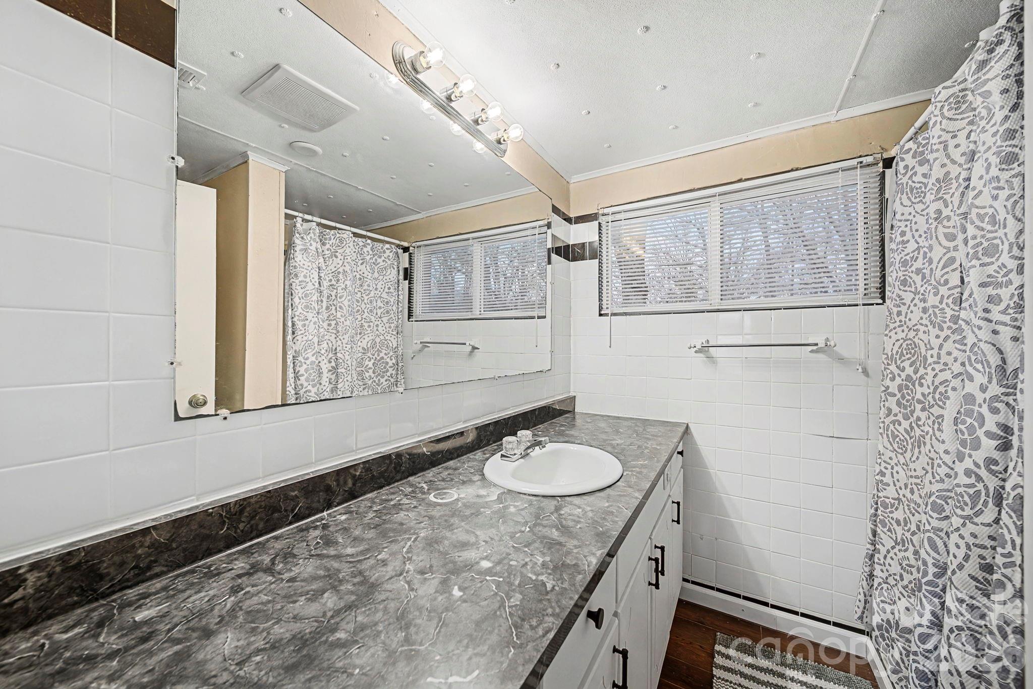 14309 Liberty Hill Church Road Oakboro, NC 28129 - Photo 20 of 37 a bathroom with a sink toilet a mirror and shower