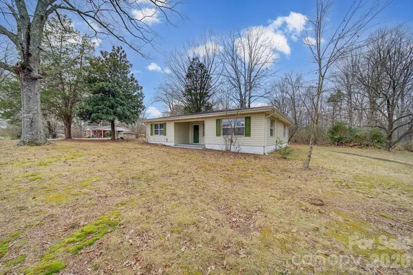 a front view of house with yard and trees around
