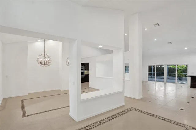 a view of a hallway with wooden floor and chandelier
