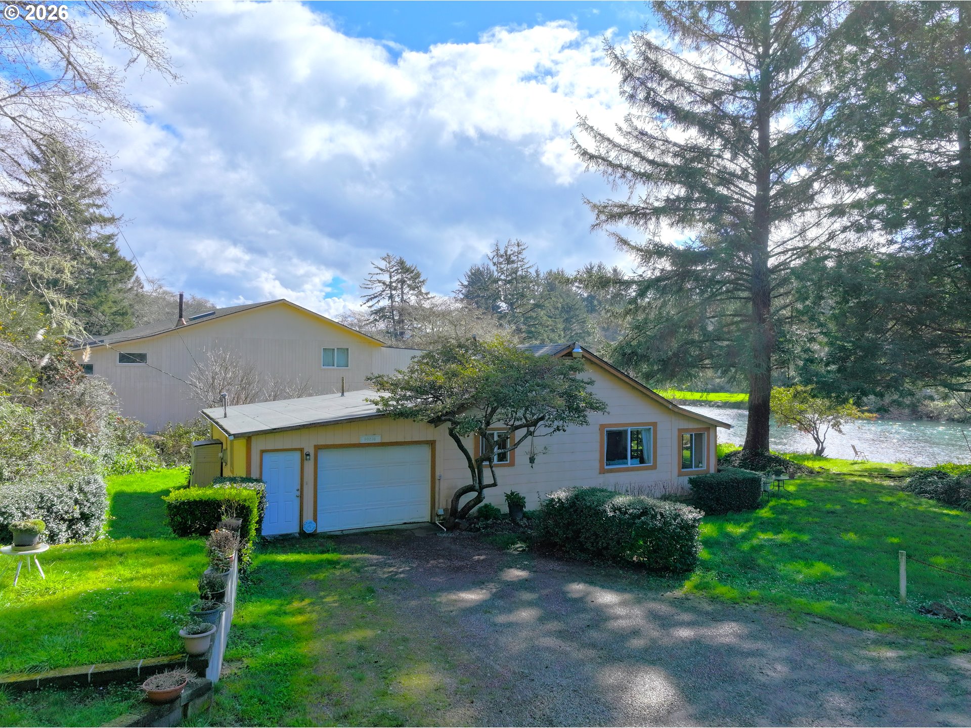 99270 Winchuck River Road Brookings, OR 97415 - Photo 1 of 40 a front view of house with a garden