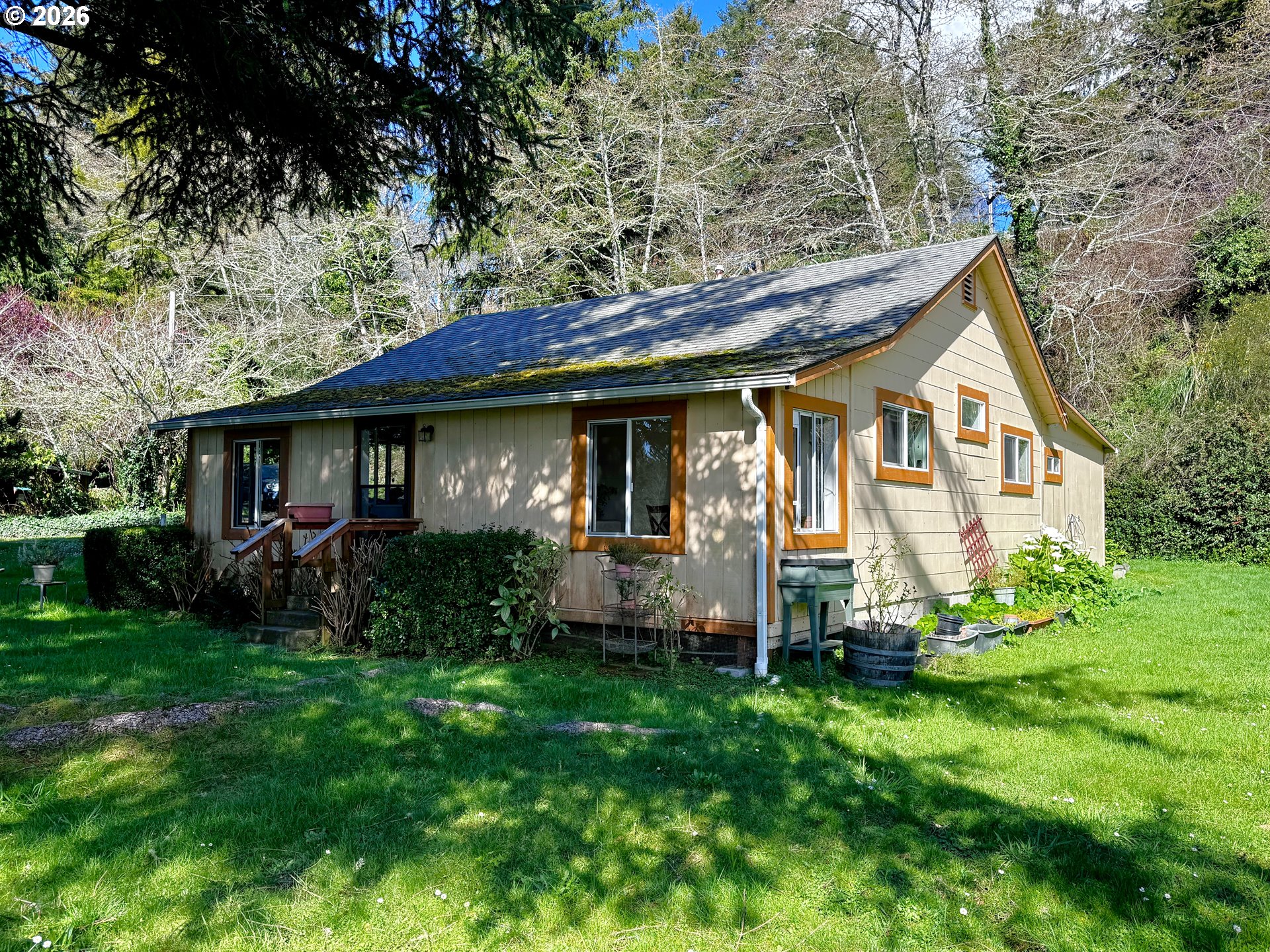 99270 Winchuck River Road Brookings, OR 97415 - Photo 5 of 40 a view of a house with a yard plants and large tree