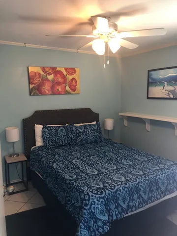 a spacious bedroom with a bed and a chandelier