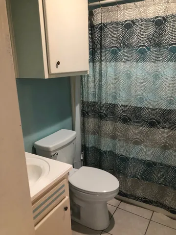 a white toilet sitting next to a bathroom sink
