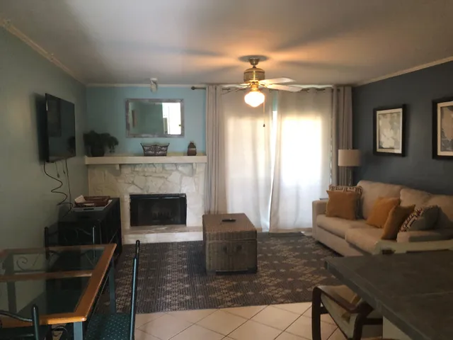 a living room with furniture a flat screen tv and a fireplace