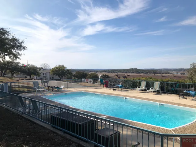 a view of a swimming pool and trees in the background