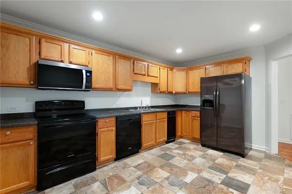 a kitchen with stainless steel appliances granite countertop a refrigerator and a sink