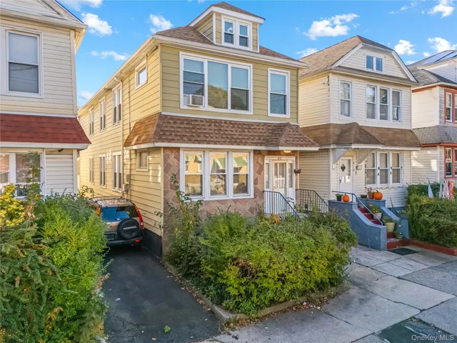 a front view of a house with plants and entryway