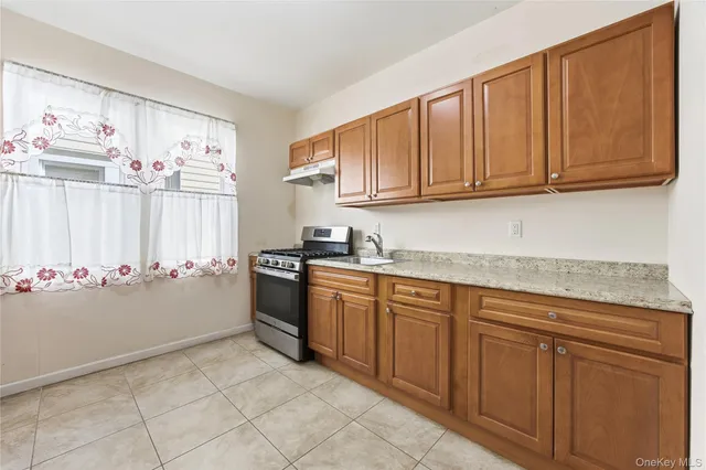 a kitchen with granite countertop white cabinets and stainless steel appliances