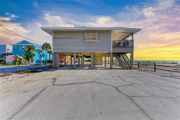 a front view of a house with a yard and potted plants
