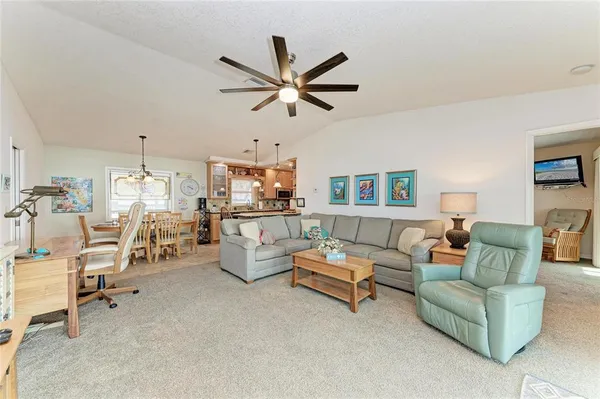 a living room with furniture ceiling fan and a window