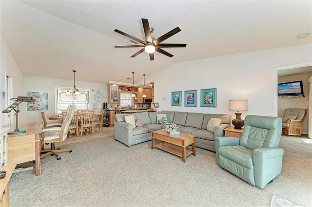 a living room with furniture ceiling fan and a window