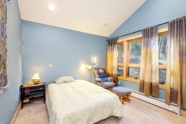 a bedroom with a bed and a lamp next to a window