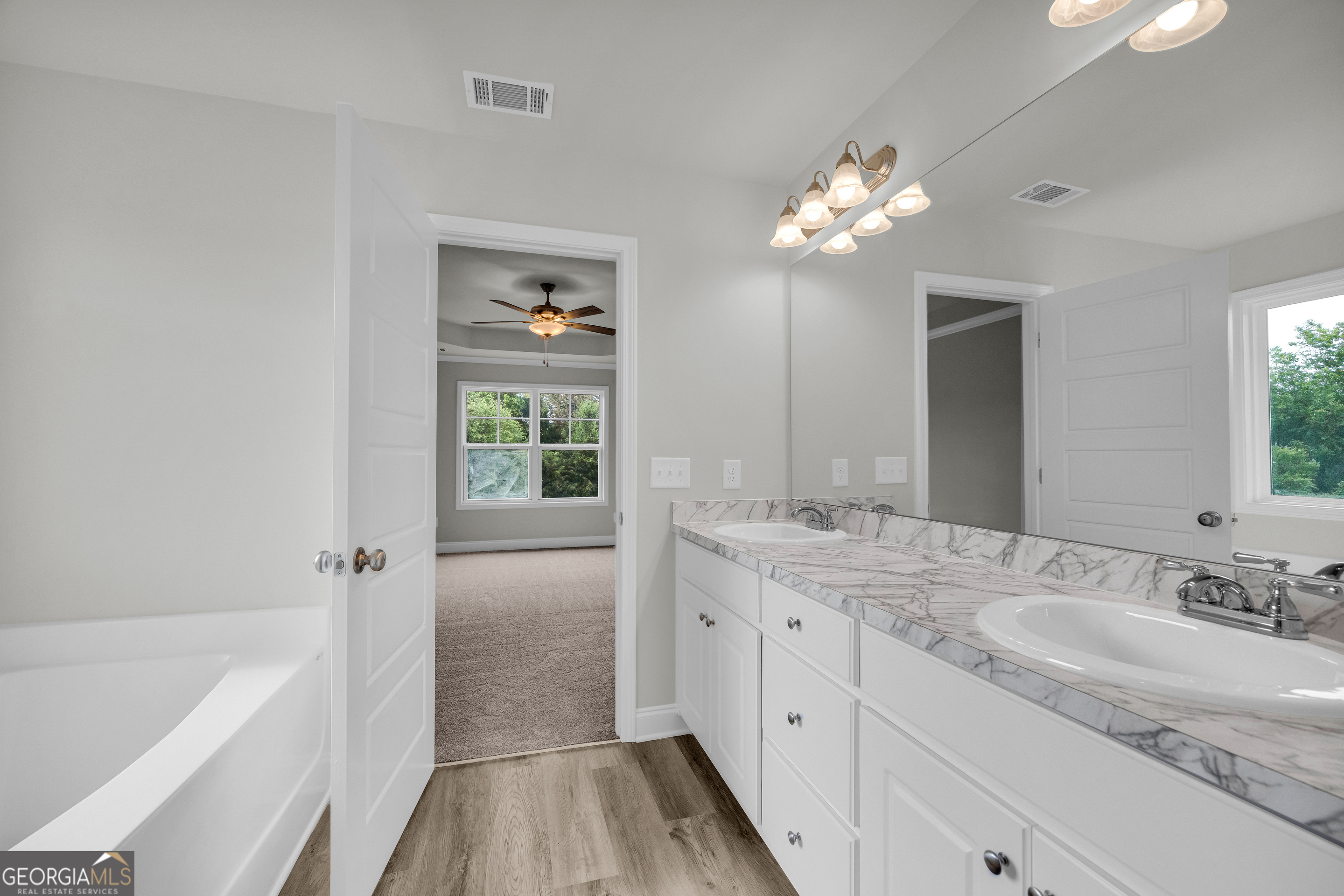 110 Sewell Road Lavonia, GA 30553 - Photo 19 of 73 a bathroom with a sink a large mirror and a bathtub