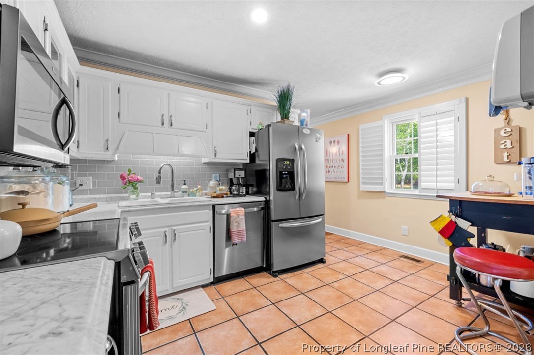310 Canady Street Fayetteville, NC 28306 - Photo 11 of 50 a kitchen with stainless steel appliances granite countertop a refrigerator sink and wooden cabinets
