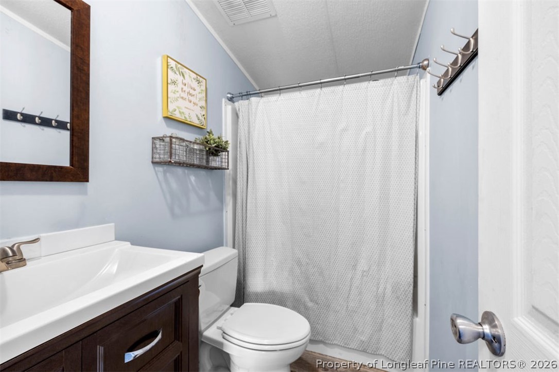 310 Canady Street Fayetteville, NC 28306 - Photo 35 of 50 a bathroom with a sink a toilet and shower curtain