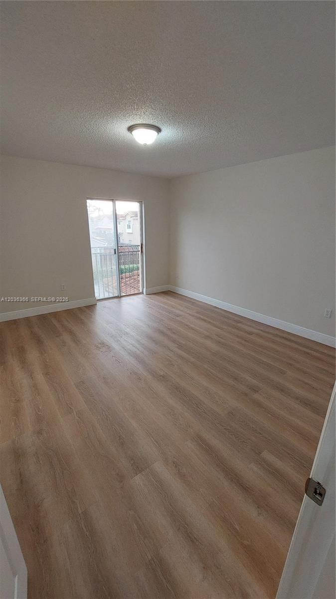 7083 Southwest 158th Court Miami, FL 33193 - Photo 13 of 22 an empty room with wooden floor and windows