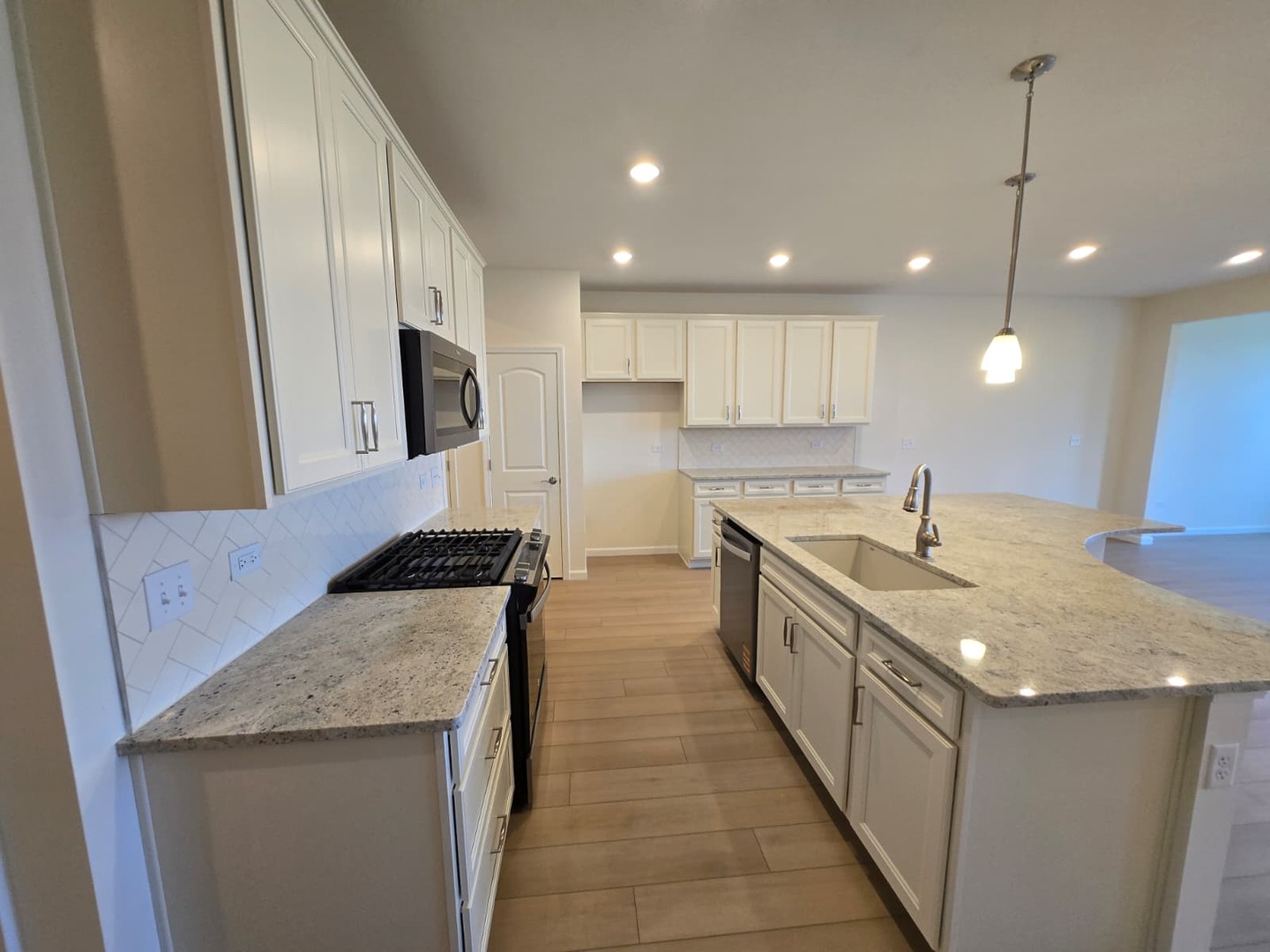 668 Switchgrass Way, Unit 58004 Bolingbrook, IL 60490 - Photo 11 of 31 a large kitchen with stainless steel appliances granite countertop a sink a stove and a refrigerator
