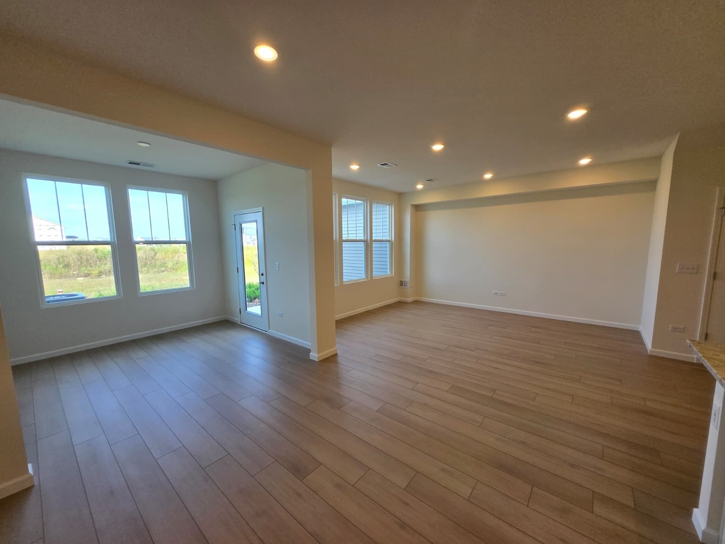 668 Switchgrass Way, Unit 58004 Bolingbrook, IL 60490 - Photo 14 of 31 an empty room with wooden floor and windows