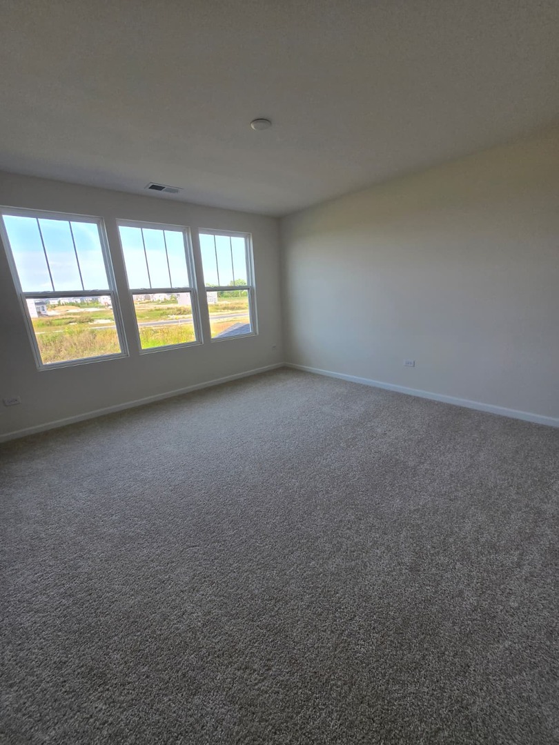 668 Switchgrass Way, Unit 58004 Bolingbrook, IL 60490 - Photo 15 of 31 an empty room with a window