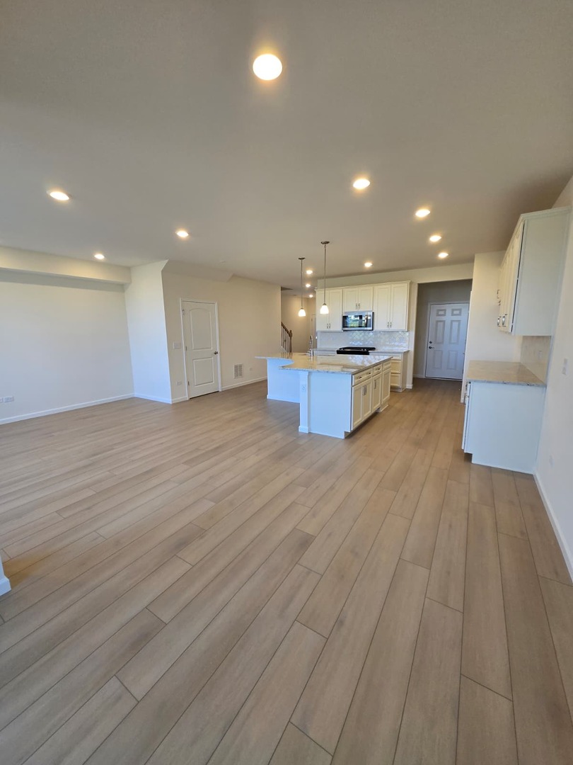 668 Switchgrass Way, Unit 58004 Bolingbrook, IL 60490 - Photo 17 of 31 a view of kitchen with kitchen island wooden floor center island and stainless steel appliances