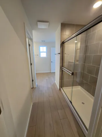 a bathroom with a glass door shower and a sink