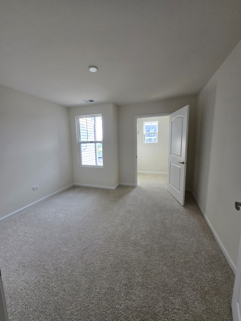668 Switchgrass Way, Unit 58004 Bolingbrook, IL 60490 - Photo 22 of 31 a view of empty room with windows