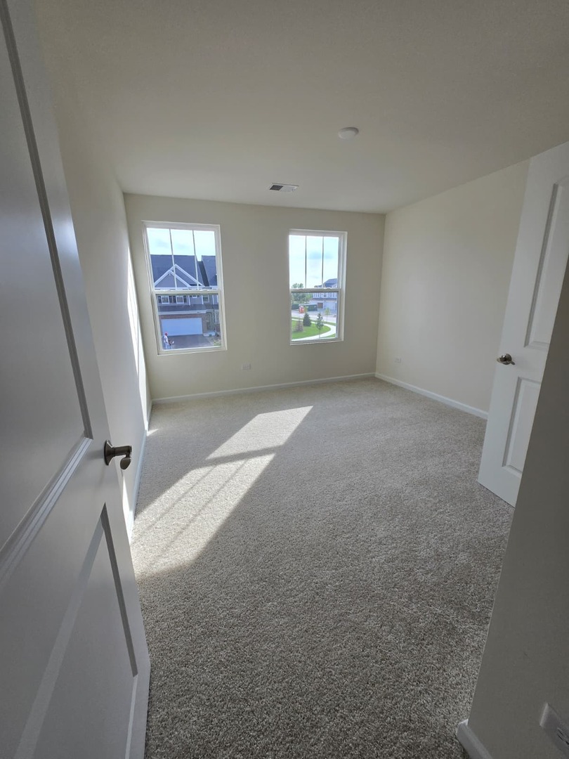 668 Switchgrass Way, Unit 58004 Bolingbrook, IL 60490 - Photo 23 of 31 an empty room with windows