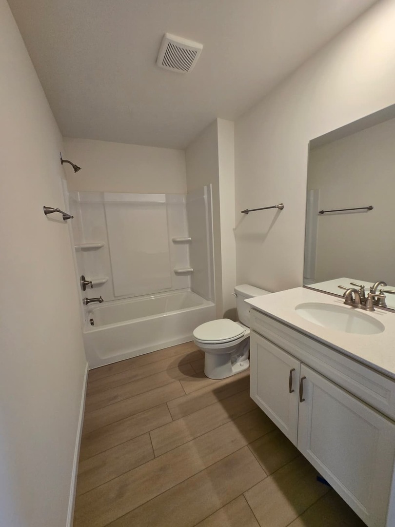 668 Switchgrass Way, Unit 58004 Bolingbrook, IL 60490 - Photo 26 of 31 a spacious bathroom with a granite countertop sink a toilet and shower