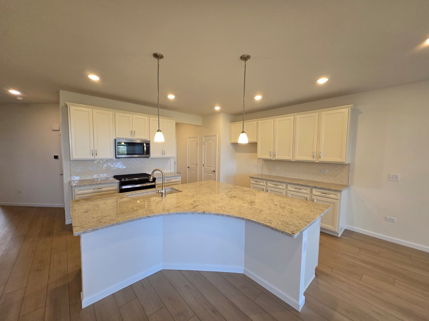 668 Switchgrass Way, Unit 58004 Bolingbrook, IL 60490 - Photo 7 of 31 a kitchen with stainless steel appliances a stove sink and microwave