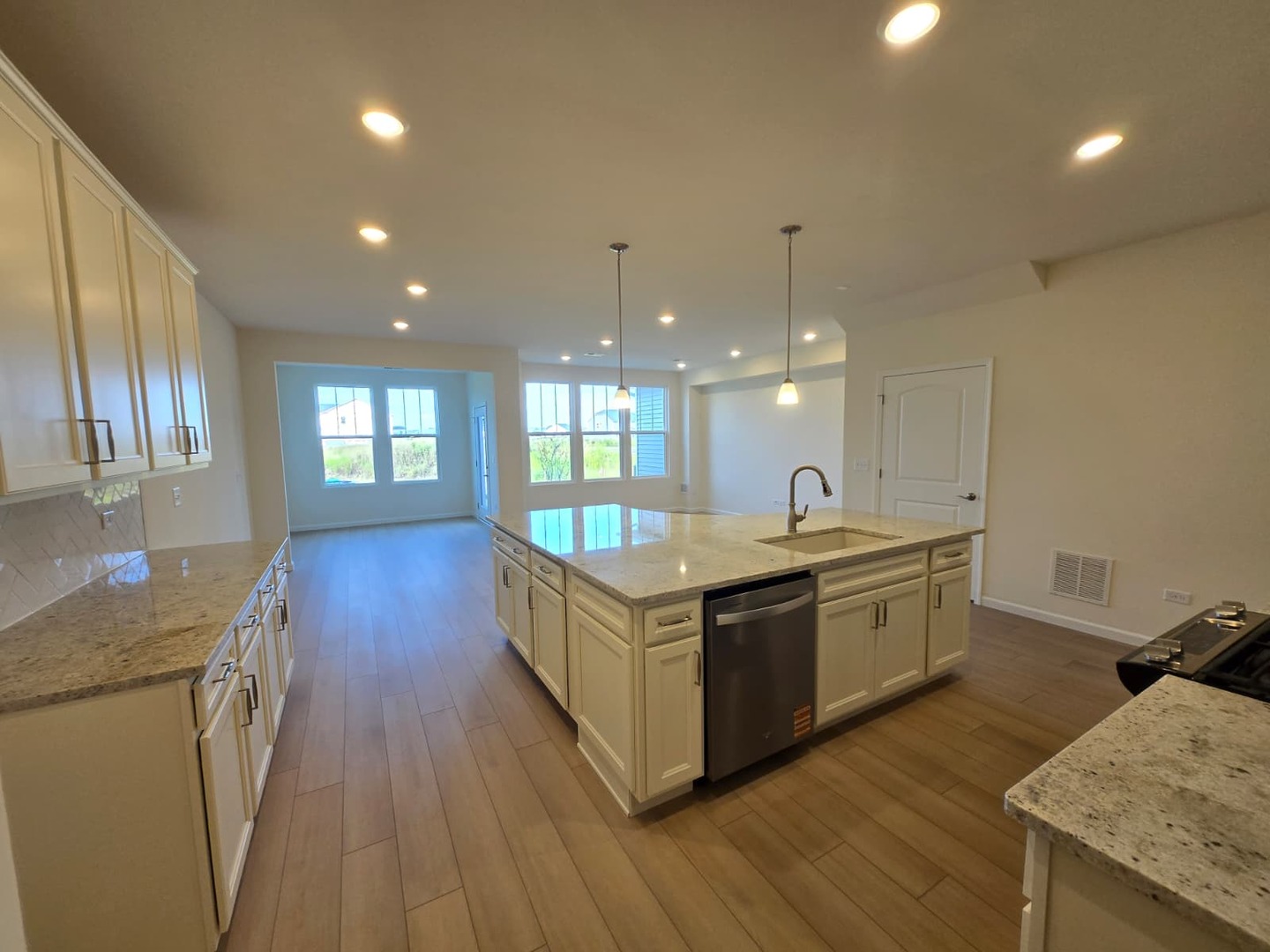 668 Switchgrass Way, Unit 58004 Bolingbrook, IL 60490 - Photo 8 of 31 a large kitchen with stainless steel appliances granite countertop a lot of counter space and wooden floors