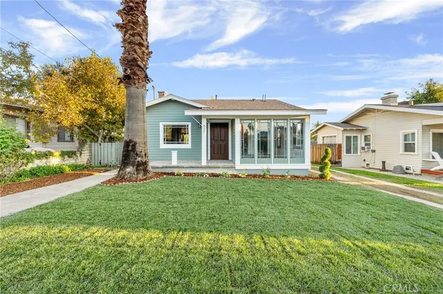 a front view of a house with a garden and yard