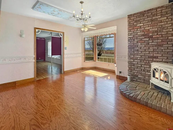 a view of empty room with wooden floor and fireplace