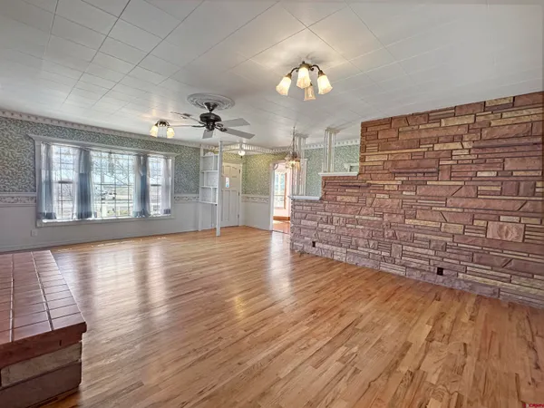 a view of an empty room with wooden floor and a floor to ceiling window