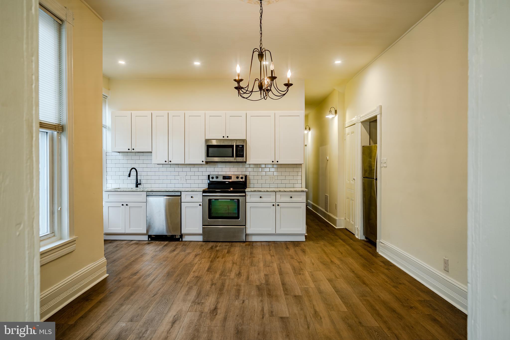 a kitchen with stainless steel appliances a refrigerator sink and microwave