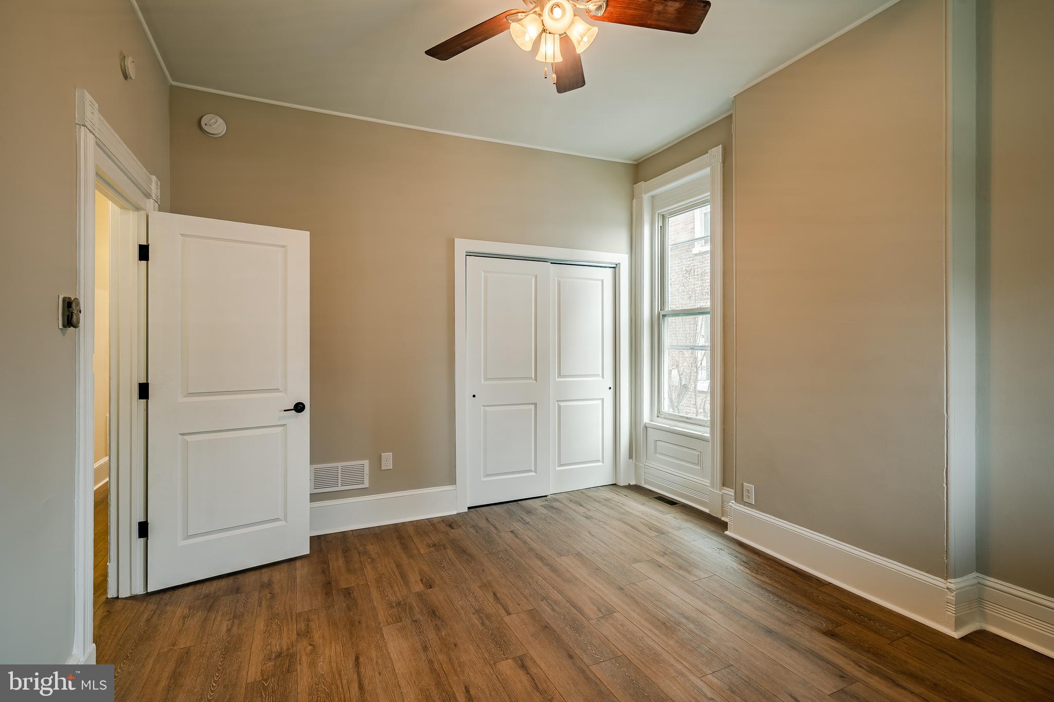 144 Gay Street, Unit 1 Phoenixville, PA 19460 - Photo 11 of 22 an empty room with wooden floor chandelier fan and windows