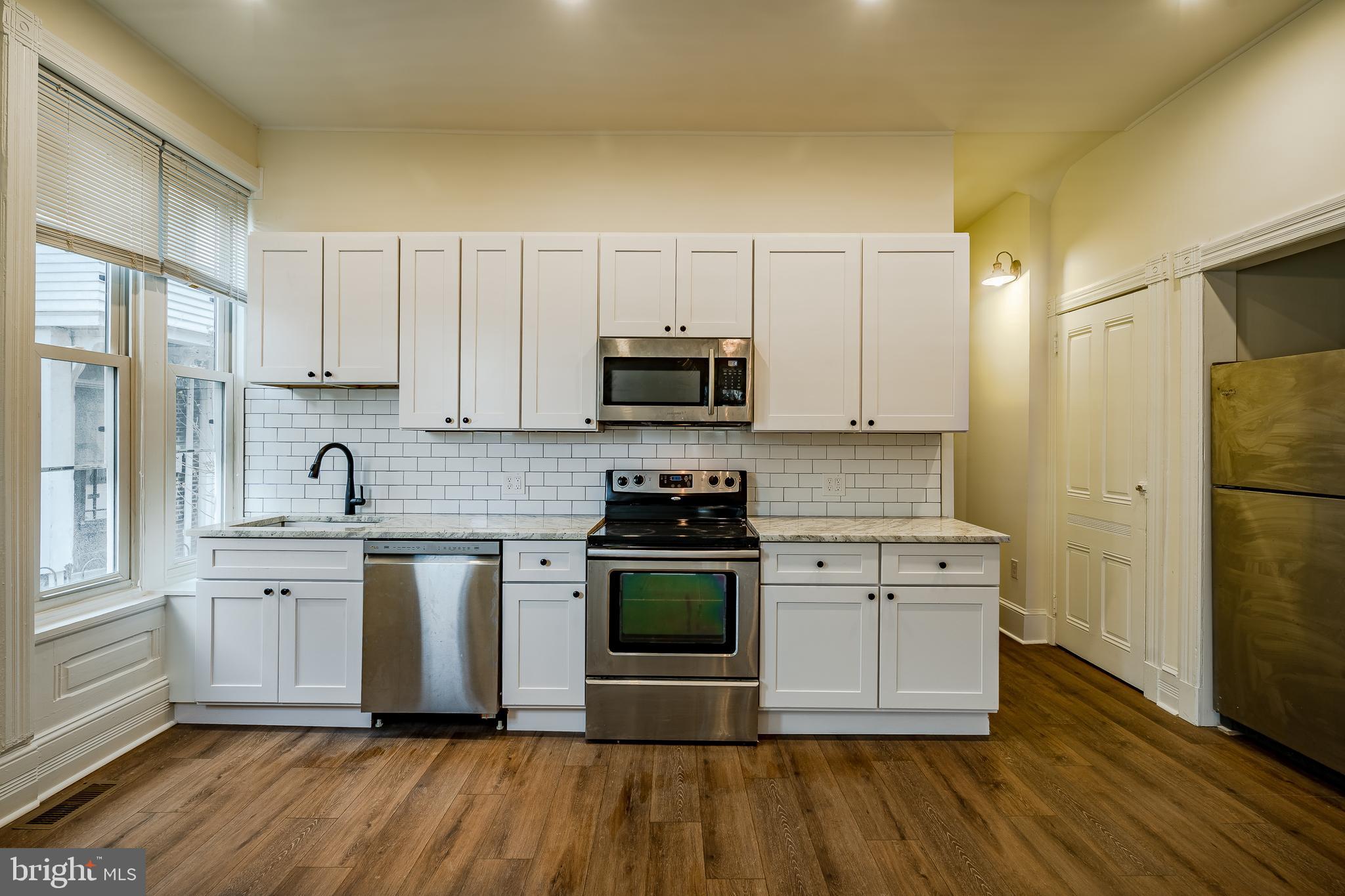 144 Gay Street, Unit 1 Phoenixville, PA 19460 - Photo 2 of 22 a kitchen with stainless steel appliances granite countertop a stove a sink and a refrigerator