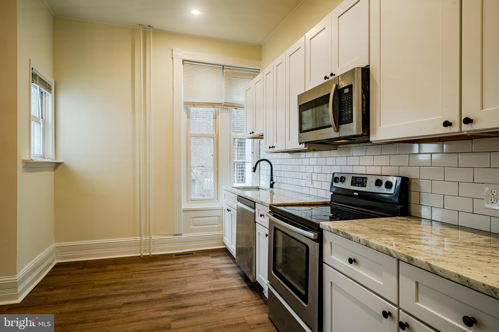 144 Gay Street, Unit 1 Phoenixville, PA 19460 - Photo 5 of 22 a kitchen with stainless steel appliances granite countertop a stove a sink and a microwave