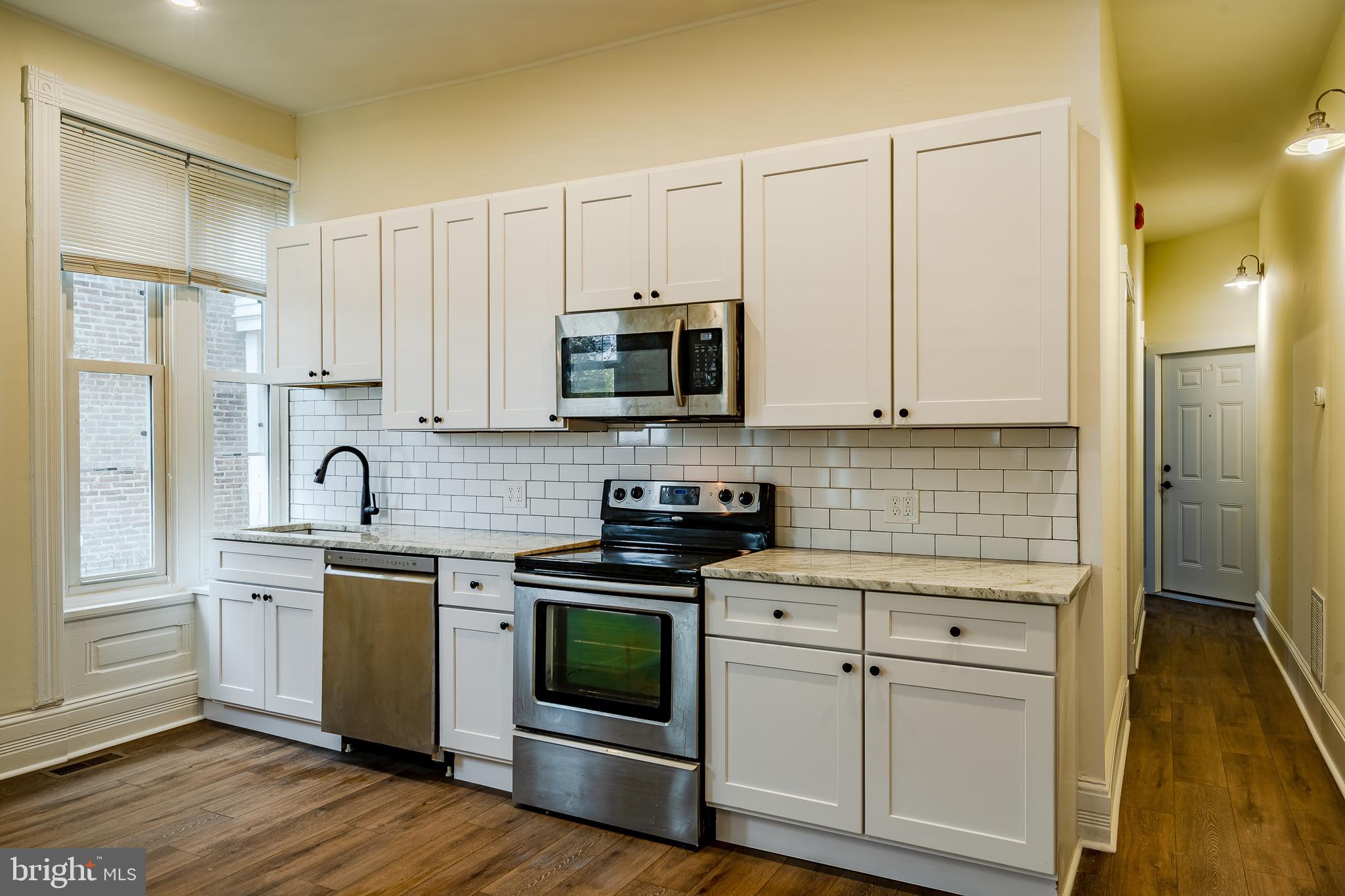 144 Gay Street, Unit 1 Phoenixville, PA 19460 - Photo 6 of 22 a kitchen with stainless steel appliances granite countertop white cabinets a sink a stove a refrigerator and white cabinets