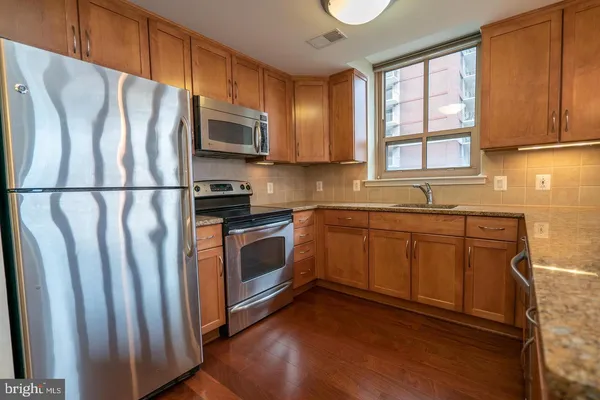 a kitchen with stainless steel appliances a refrigerator sink and microwave