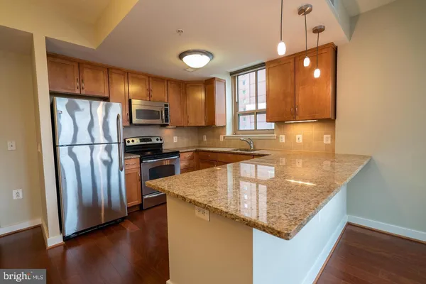 a kitchen with stainless steel appliances granite countertop a refrigerator a sink and a stove