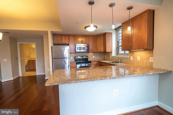 a kitchen with stainless steel appliances granite countertop a sink a refrigerator and a stove