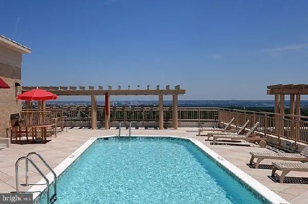 a view of a swimming pool with a patio and a yard