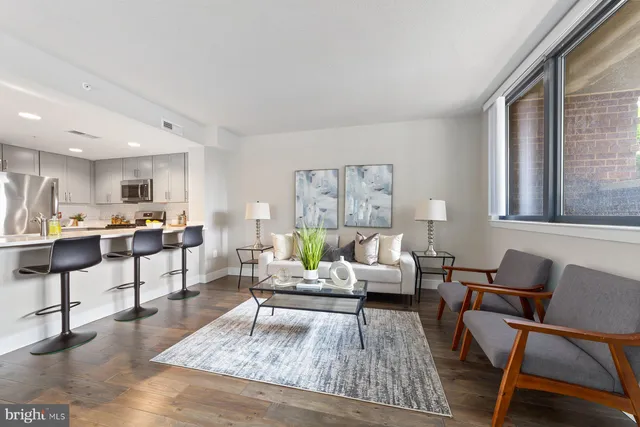 a living room with furniture and view of kitchen