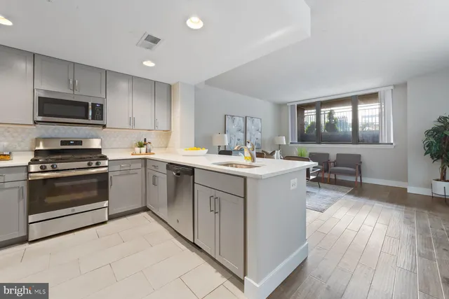 a kitchen with a sink wooden floor and stainless steel appliances