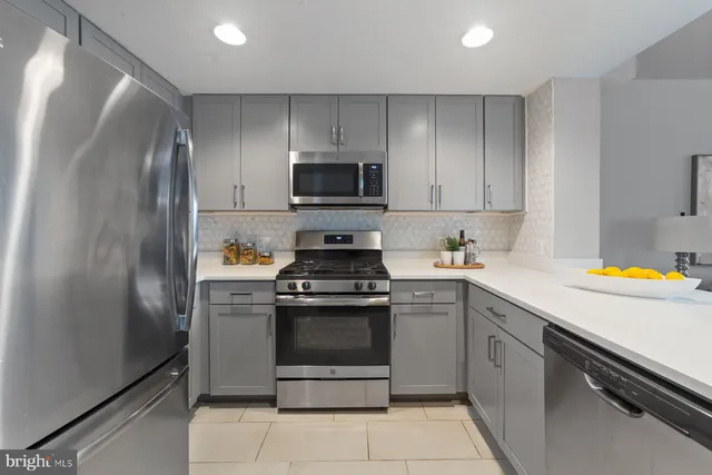 a kitchen with stainless steel appliances granite countertop a stove a refrigerator and a sink