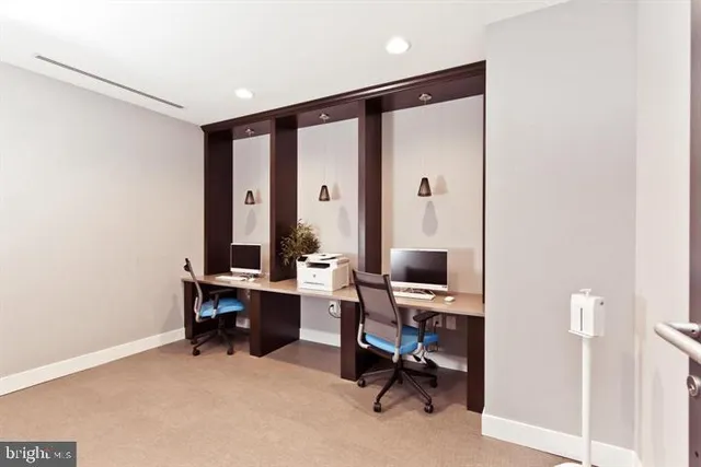 a view of a workspace with furniture and a window