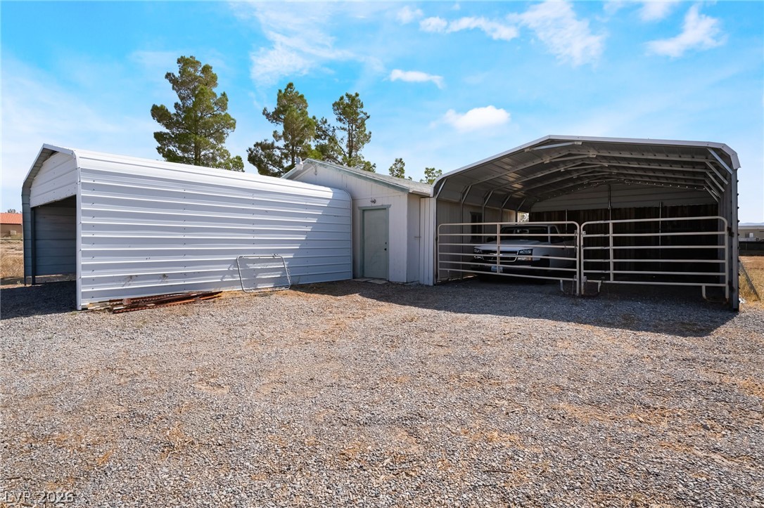 3631 South Blagg Road Pahrump, NV 89048 - Photo 41 of 47 Functional metal structures provide ample covered storage and a secure, gated carport on a spacious gravel lot.
