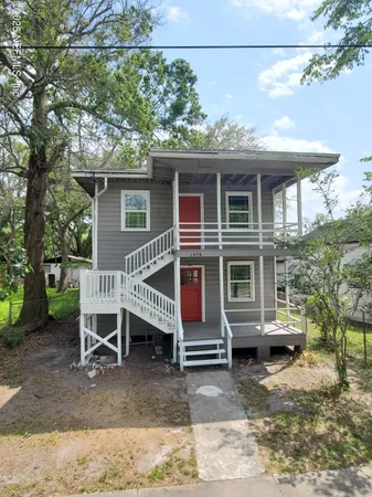 a view of a house with a patio and a yard